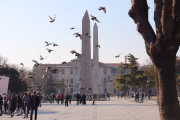 Two obelisks and swirling pigeons