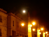 The moon seen over Jerez old town, through a haze. The streetlamps look like moons, too.