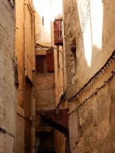 Street in medina. The round window covers up above the door are there so that women in the house could look out without being seen.