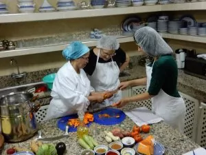 Being taught how to cut a carrot while preparing dinner