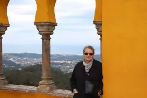 Patricia in a palace courtyard with the Atlantic Ocean in the background.
