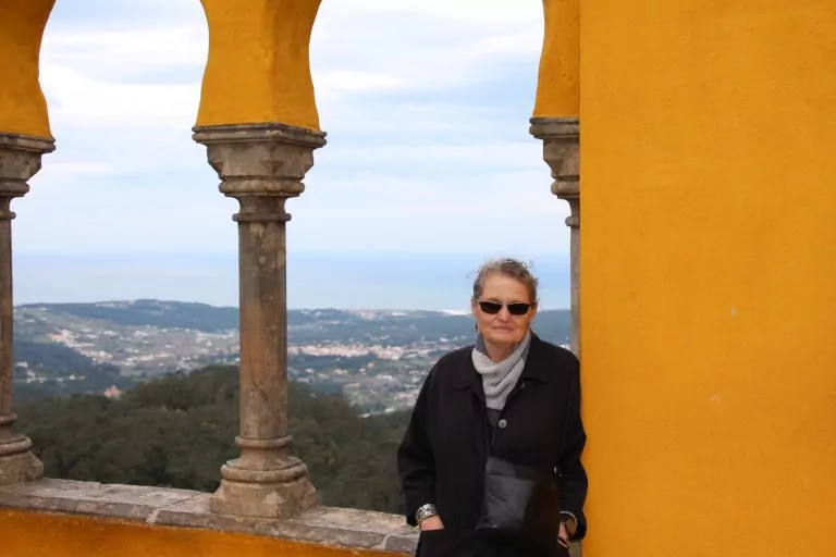 Patricia in a palace courtyard with the Atlantic Ocean in the background.